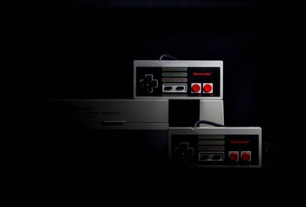 Retro gaming controllers from the Nintendo Entertainment System in low-key lighting, evoking nostalgia.
